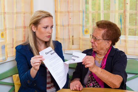 a grandson visited his grandmother and reads a generational contract.の写真素材