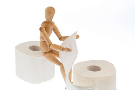 a wooden figure and a roll of toilet paper.の写真素材