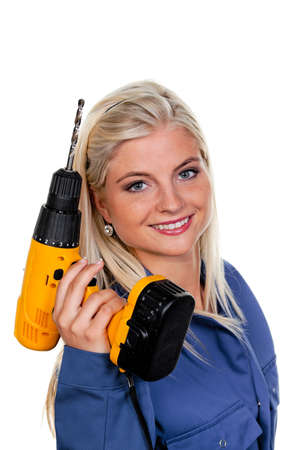 young woman in blue work clothes with a drill.の写真素材