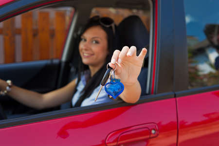 young woman with a new car and car keysの写真素材