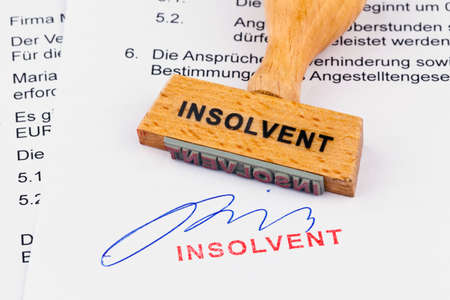 a stamp made of wood lying on a document. inscription insolventの写真素材
