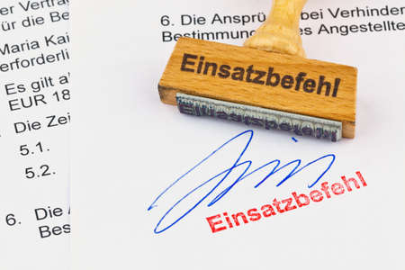 a stamp made of wood lying on a document. label use commandの写真素材