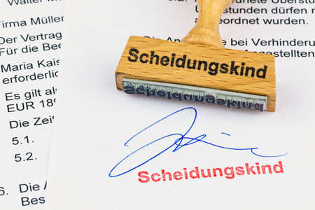 a stamp made of wood lying on a document. labeled child of divorceの写真素材