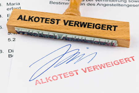 a stamp made of wood lying on a document. inscription alkotest deniedの写真素材