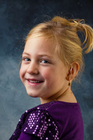 the portrait of a little girl against a gray background.の写真素材