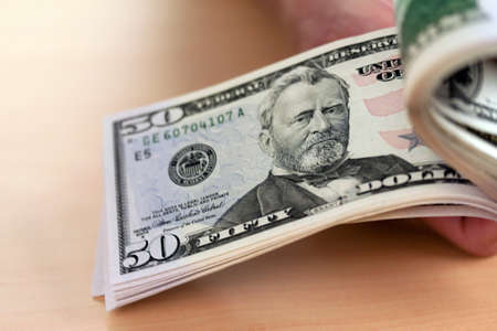 many dollar bills are counted with handsの写真素材
