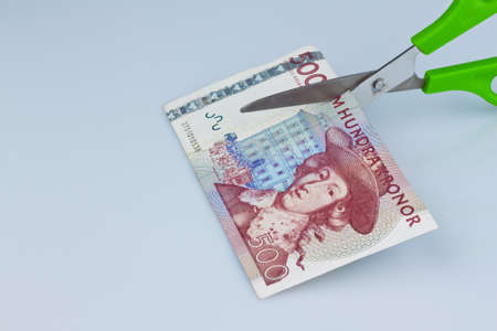 swedish krona, the currency of sweden. with scissors. levies and taxes.の写真素材