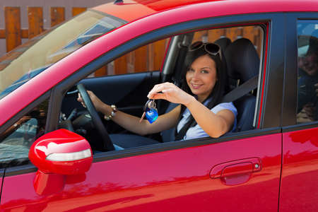 young woman with a new car and car keysの写真素材