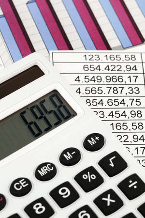a calculator and various statistics in the calculation of the balance sheet, revenue and profit の写真素材