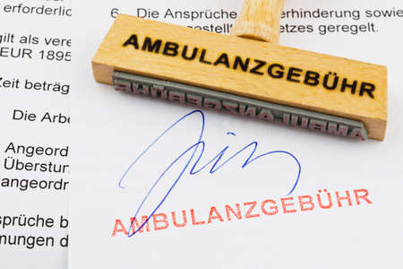 a stamp made of wood lying on a document  german words  ambulance feeの写真素材