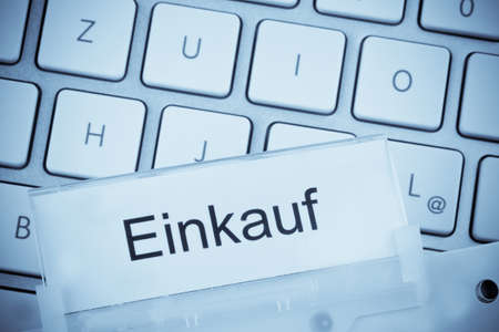 a folder for files in hanging folders in front of a computer keyboard on the topic  purchasingの写真素材