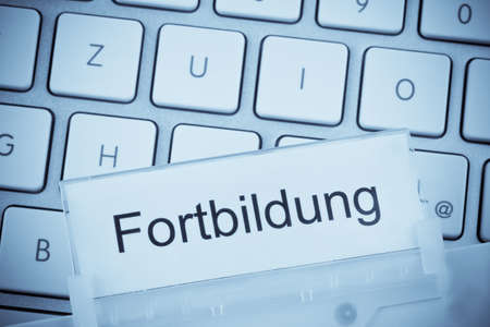 a folder for files in hanging folders in front of a computer keyboard on the topic  educationの写真素材