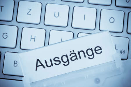 a folder for files in hanging folders in front of a computer keyboard on the topic  outputsの写真素材