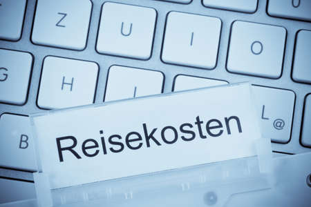 a folder for files in hanging folders in front of a computer keyboard on the theme  travelの写真素材