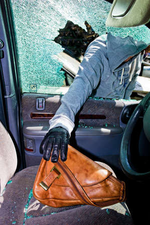a thief stole a purse from a car through a broken side window の写真素材