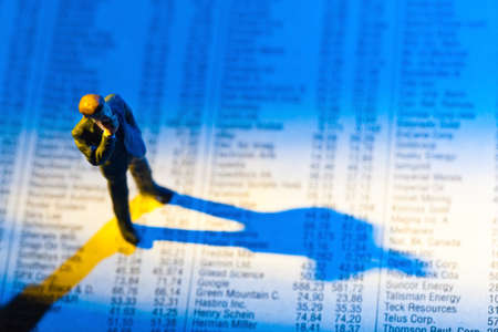 a small figure and the prices of shares in a newspaper  make money on the stock exchange  gains and losses in stock trading の写真素材