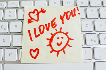 a memo is on the keyboard of a computer to remember  i love youの写真素材