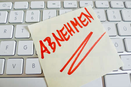 a memo is on the keyboard of a computer as a reminder: decrease a memo is on the keyboard of a computer as a reminder: decrease