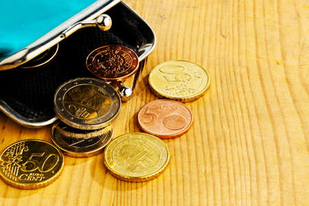 coins and an empty wallet with a few â‚¬. photo icon on debt and poverty