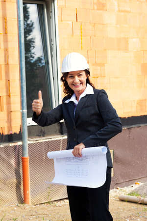 architects with blueprint before shell of a house building a house の写真素材