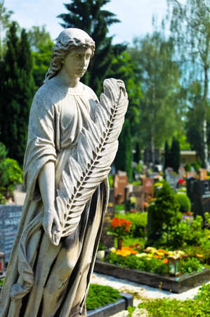 an angel watches as a statue on the tomb in a cemeteryのeditorial素材