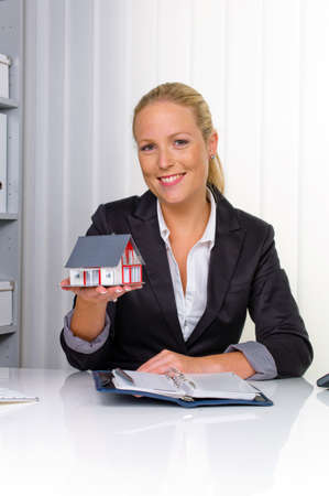 a young real estate agent with a model home in her office の写真素材