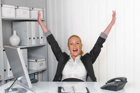 a young successful woman sitting at her desk in the office の写真素材