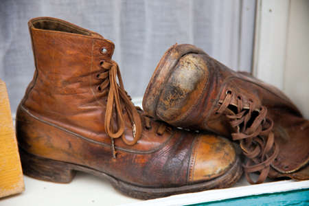 old, used shoes are in a shop window of a shop