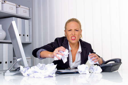 a woman in the office with paper balls  anger, stress and frustration in the workplaceの写真素材