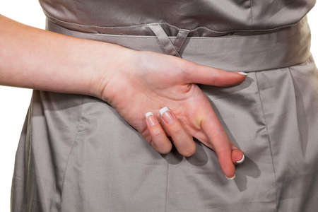 the crossed fingers of a business woman  tax evasion and lies in businessの写真素材