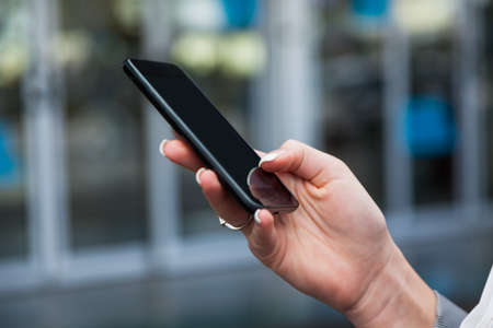 businesswoman writing at the airport sms. roaming charges when abroad