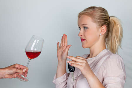 a young woman with car keys refused a glass of wine  do not drink and driveの写真素材