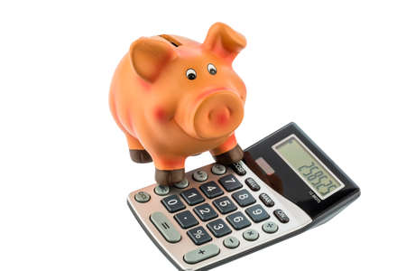 a calculator beside a piggy bank  profitability when investing money  interest rates for saversの写真素材