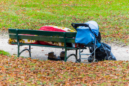 on a park bench has a homeless man resigned to sleepの写真素材