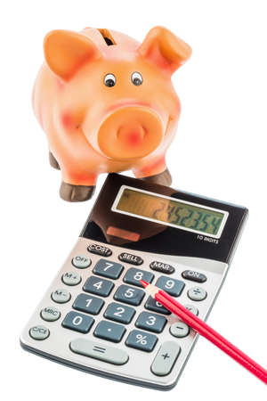 a red pen on a calculator beside a piggy bank  save on costs, expenditures and budget  interest rates for saversの写真素材