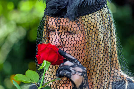 a young, grieving widow with a veil and rose  death and inheritance の写真素材