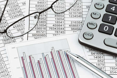 a calculator is on a balance sheet numbers are statistics  photo icon for sales, profit and cost 