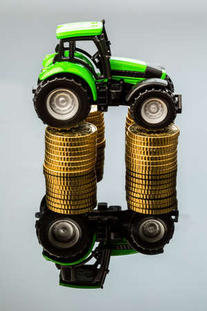 farmers in agriculture have to reckon with rising costs  higher prices for food, fertilizer and plants  tractor with coinsの写真素材