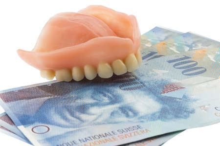 dentition and the swiss franc symbol photo of dentures, treatment costs and paymentの写真素材