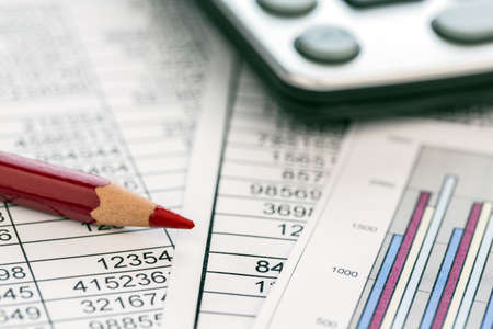 a calculator is on a balance sheet numbers are statistics  photo icon for sales, profit and cost の写真素材