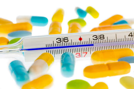 a thermometer and tablets  symbolic for flu and coldsの写真素材