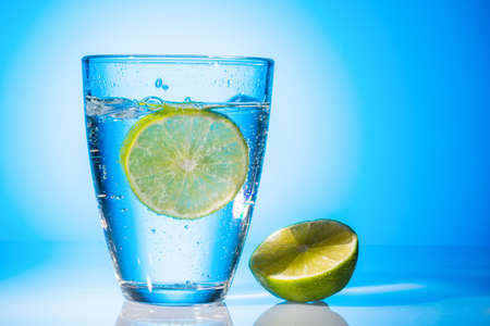 a glass of fresh drinking water and a lime  mineral water as a thirst quencher の写真素材