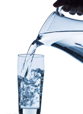 pure water is emptied into a glass of water from a pitcher  fresh drinking water