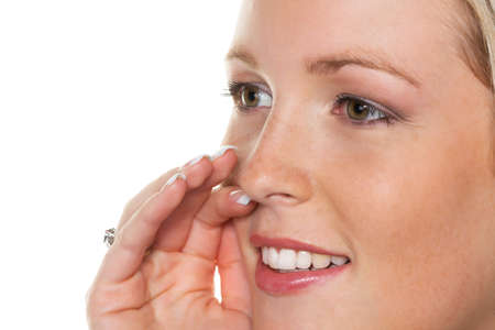 a young woman holds her hand to her mouth and tells a secret more