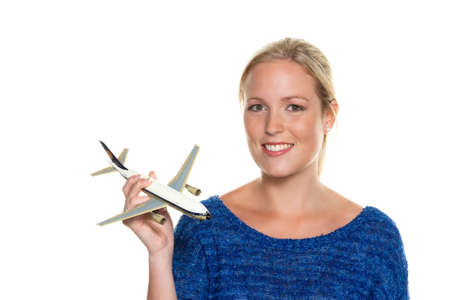 a young woman with the model of an aircraft looking forward to your next vacation の写真素材