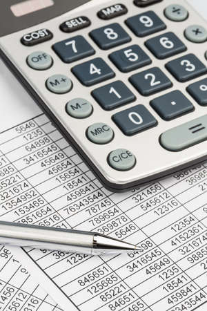 a calculator is on a balance sheet numbers are statistics  photo icon for sales, profits and costs の写真素材