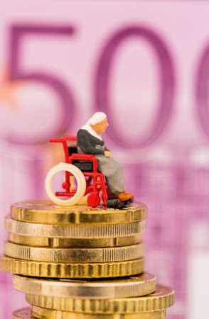woman in wheelchair on money stackの写真素材