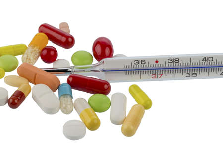 a thermometer and tablets lying on a white background