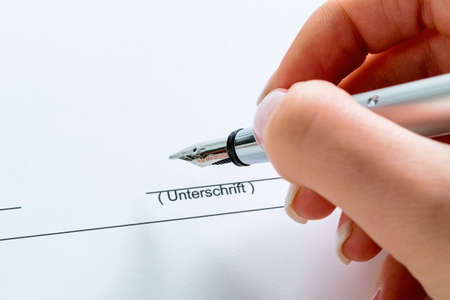 a hand with a fountain pen in the untrerschrift under a contract or testament.の写真素材
