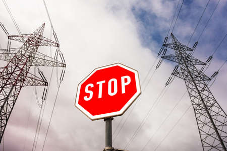 a poles of a power line and a stop sign. の写真素材